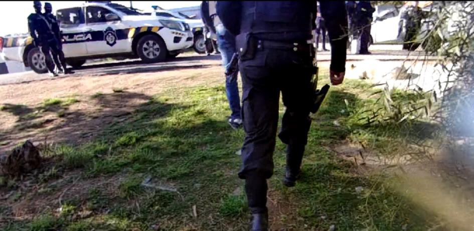 policías y móviles saliendo desde un allanamiento policías y móviles saliendo desde un allanamiento