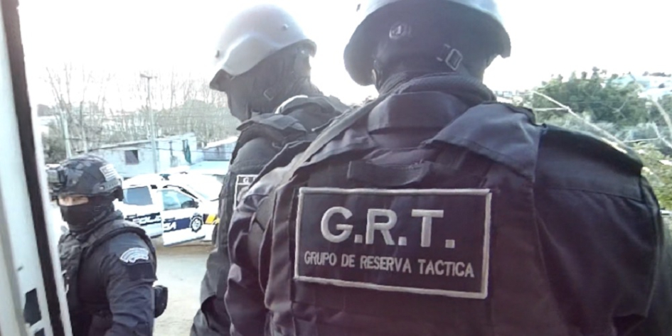 espalda de policías de grupo de reserva táctica con rostros cubiertos