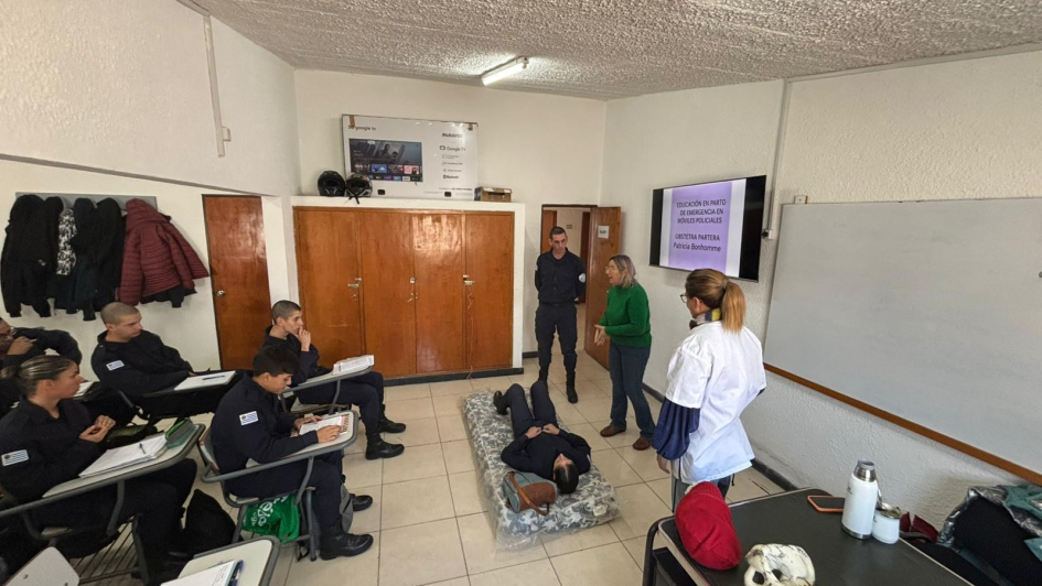 Almumnos y policías con instructora de parto de emergencia en dólares