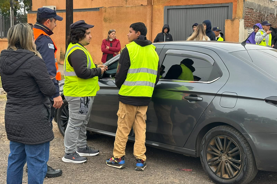 Alumnos entregando folleto a automovilista