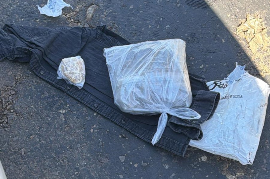 Bolsas de nylon con estupefacientes sobre una chaqueta jeans en el piso Bolsas de nylon con estupefacientes sobre una chaqueta jeans en el piso