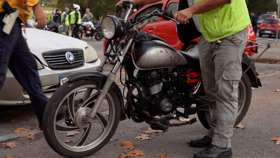 Inspección de moto durante operativo de control vehicular Personal inspecciona una moto durante un operativo de control vehicular en la vía pública.