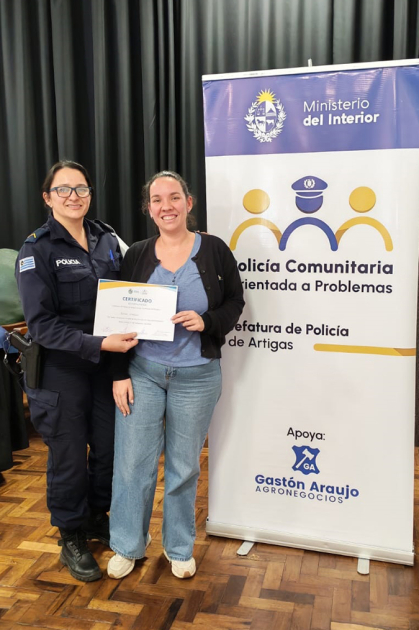 Cabo Paola Sabina Pisacco entregando certificado a participante en Escuela de Seguridad Ciudadana