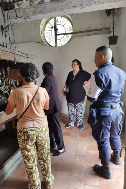 Cabo Marisel Gomez con personal de Policía Comunitaria mostrando el reloj de Jefatura a visitantes.