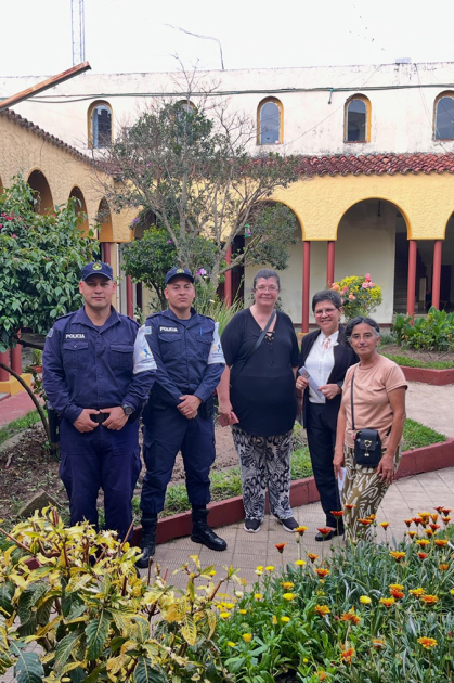Cabo Marisel Gomez y personal de Policía Comunitaria junto a visitantes en patio interno de Jefatura