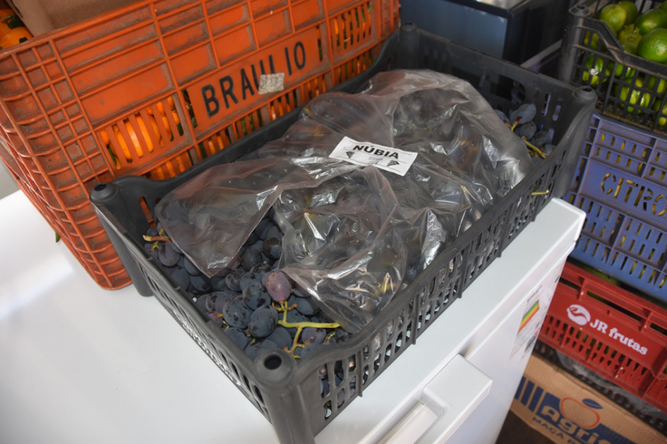 Caja plástica con uvas.