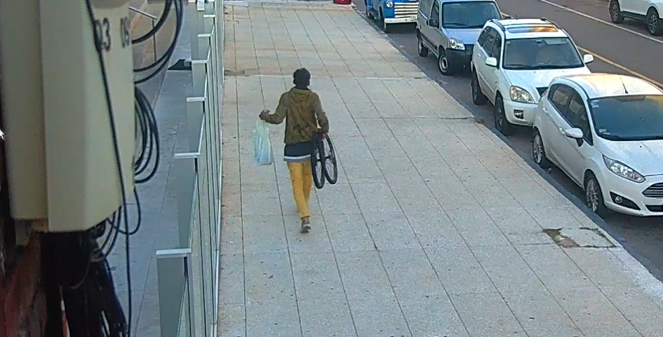 Un condenado por tentativa de hurto en Punta del Este un hombre caminando por la vereda llevando ruedas de bicicleta en la mano