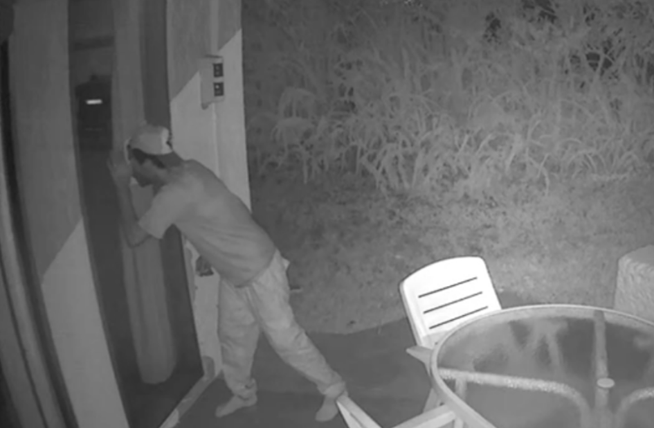 Autor del Hurto un hombre parado mirando a través de una puerta de vidrio