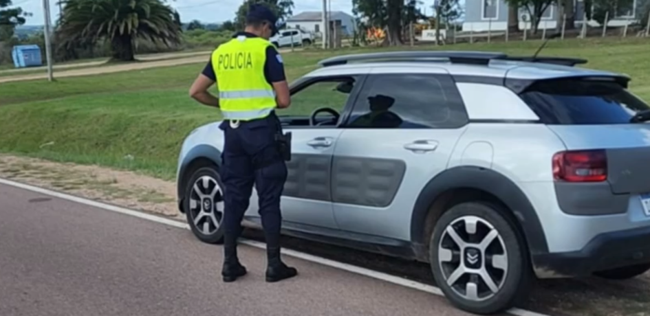 policia identificando persona en un vehiculo auto