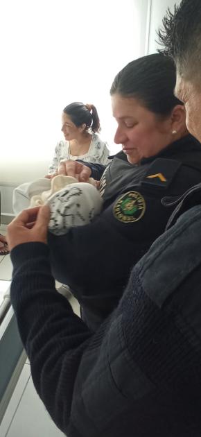 Policias con bebé en brazos de ella y su mamá detras Visiata de Policias con bebé en brazos de ella y su mamá detras