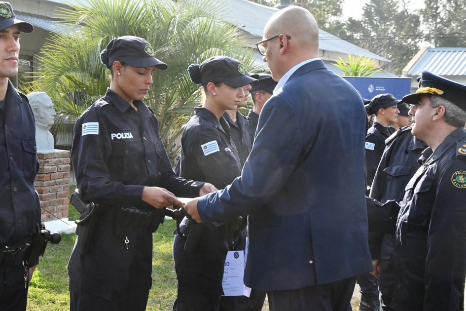 una mujer policía recibiendo su diploma durante la ceremonia de egreso de policías