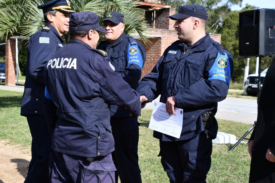 dos policías parados frente a otros dos policías estrechando las manos