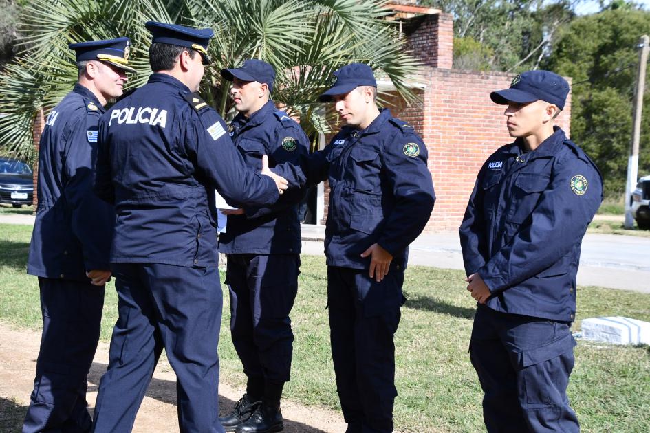 dos policías parados frente a otros tres policías estrechándose las manos