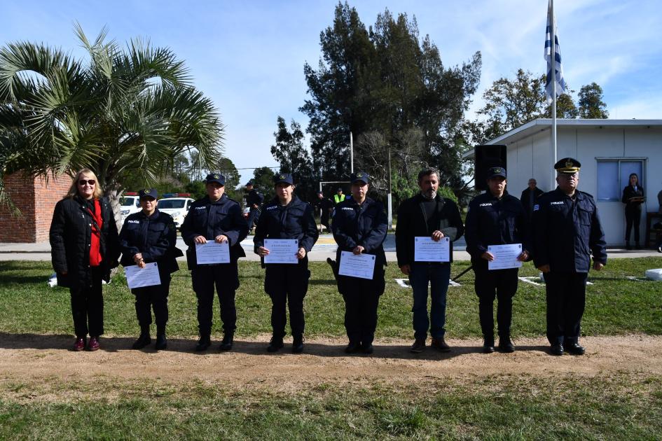 seis policías parados mostrando los diplomas recibidos 
