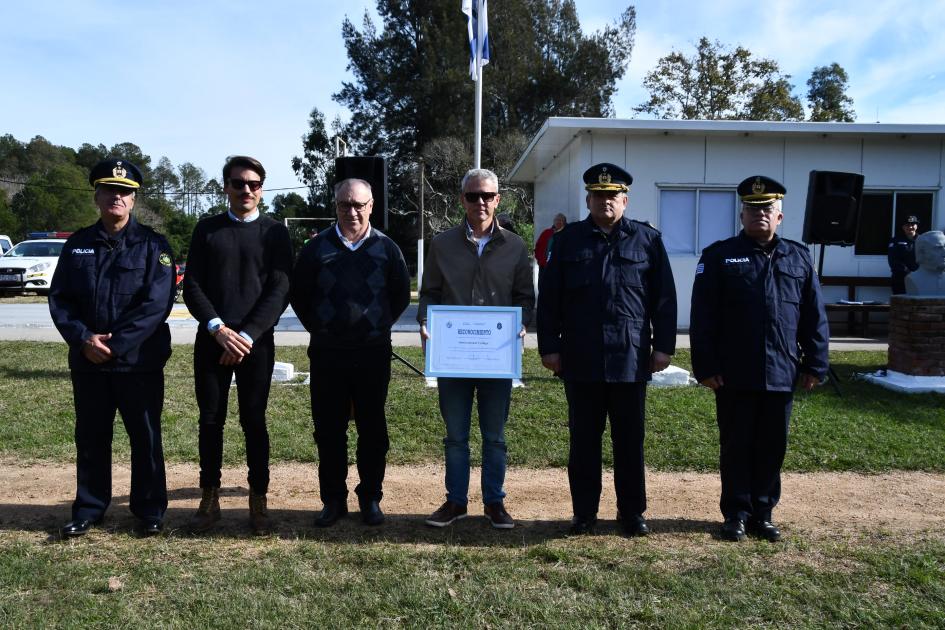 personas de mostrando el reconocimiento que recibieron por una donación a la Escuela Policial