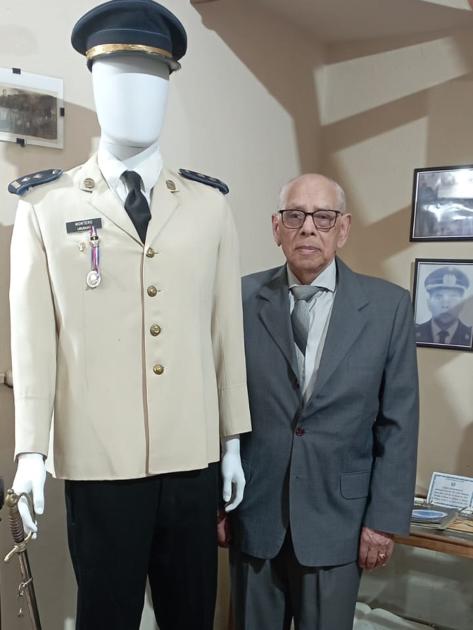 Comisario Inspector Retirado Carlos Montero posando junto a maniquí con uniforme y sable donados