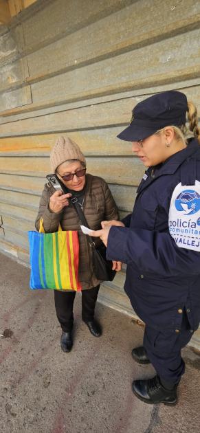 Comunitaria entregando folleteria a adultos mayores 