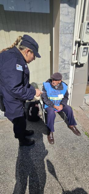 Comunitaria entregando folleteria a adultos mayores 