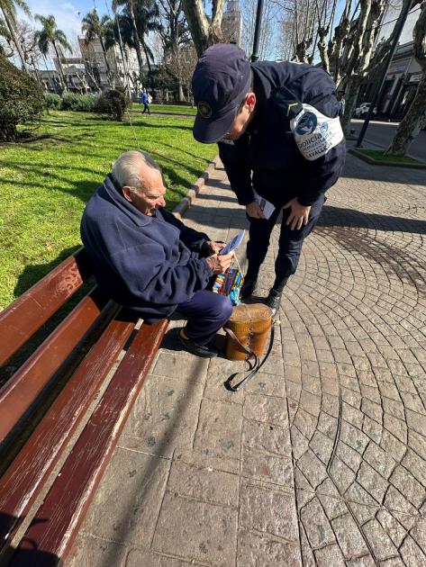 Comunitario entregando folleteria a adultos mayores en Plaza Libertad