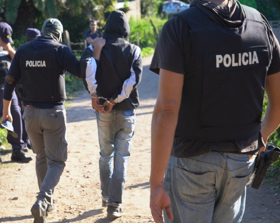 Detenido esposado llevado por policías