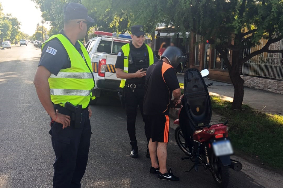 Dos policias controlando una moto con un ocupante. Dos policias controlando una moto con un ocupante.