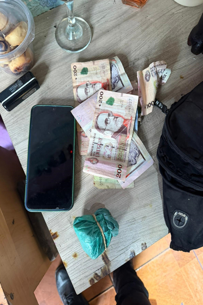 Envoltorio de nylon con droga, dinero y equipo celular incautados por la policía