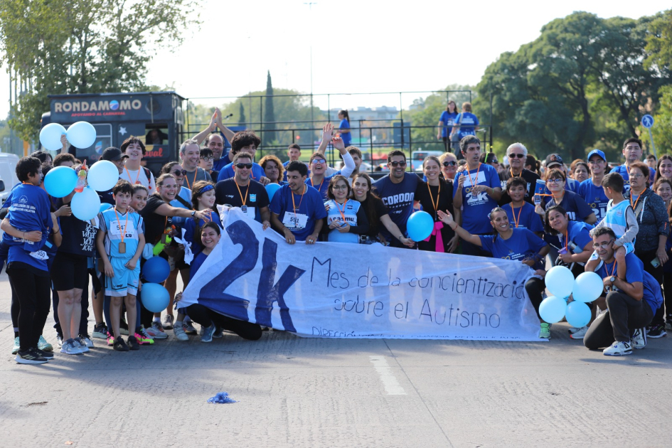 Pancarta 2K y participantes de la correcaminata por el mes de concientización del autismo
