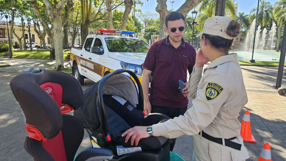 En Minas, agente instaladora explica el sistema de retención infantil para bebés a un padre