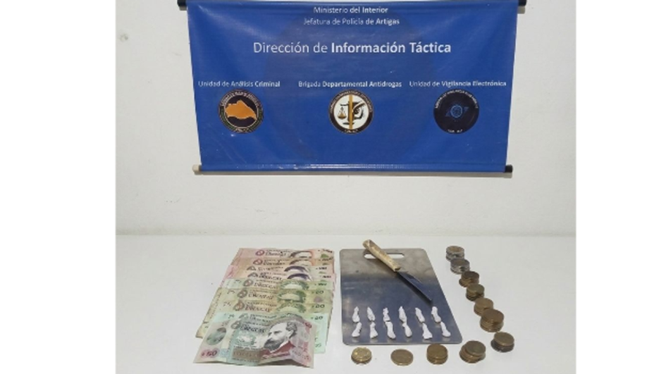 Fotografía de incautación de dinero, estupefacientes, cuchillo y una placa de metal de dinero.