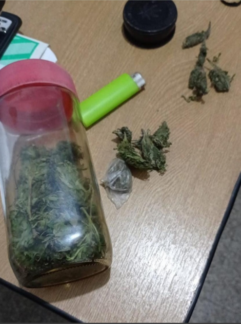 Droga incautada dos menores frente a una institución pública de Melo. Encendero de color verde flúor y frasco con marihuana.
