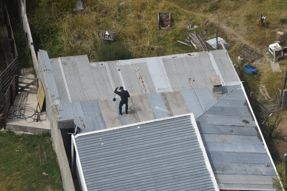 Policía incautando el morral sobre el techo de la vivienda Policía incautando el morral sobre el techo de la vivienda