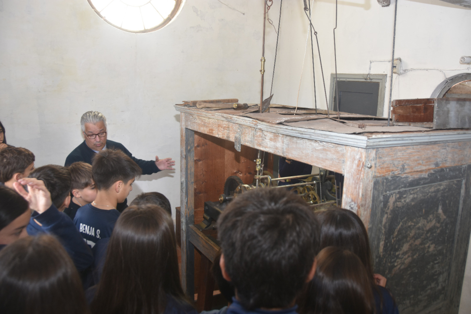 Grupo de niños observando el reloj instalado en el frontispicio de la Jefatura