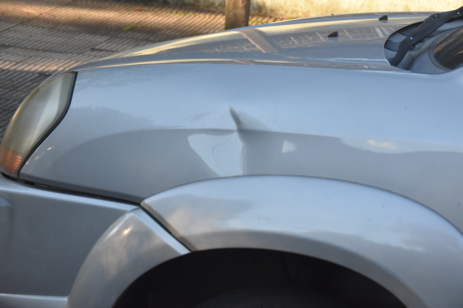 Guardabarros delantero del automóvil visible sobre la rueda delantera.