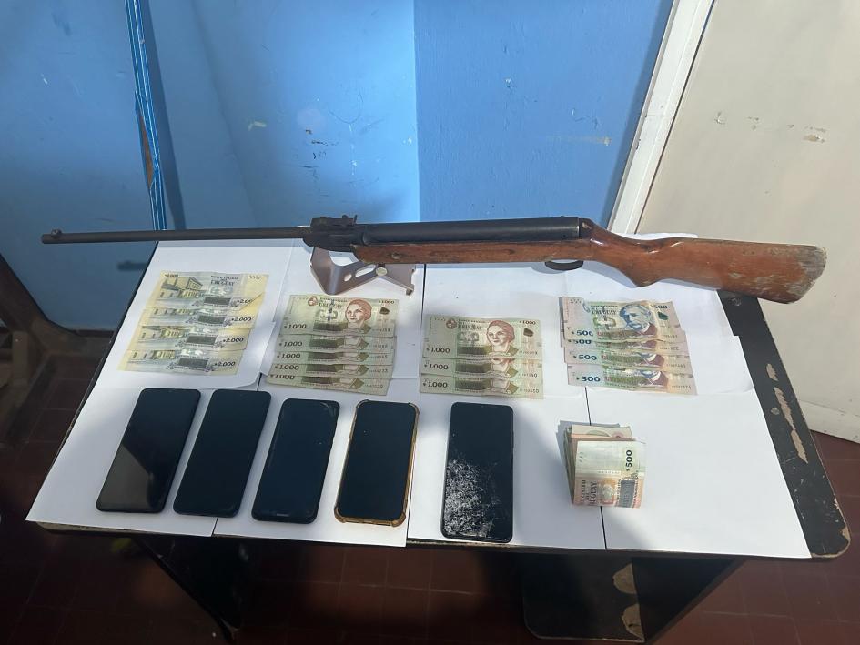 Arma, dinero y celulares incautados. Arma, dinero y celulares incautados.