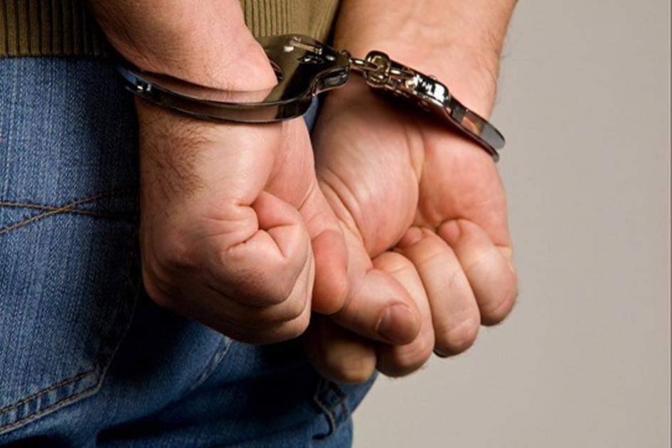 Formalizados por homicidio y encubrimiento persona esposada con las manos en la espalda