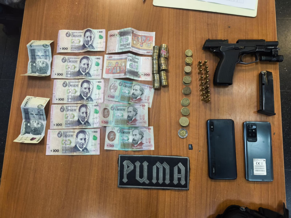 Pistola, cargador, balas, monedas, billetes, celulares y un parche con la palabra "PUMA".