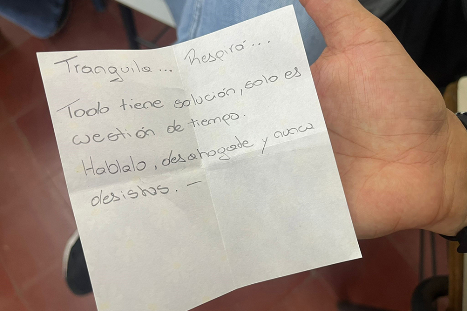 Mano sosteniendo un papel con un mensaje de aliento.