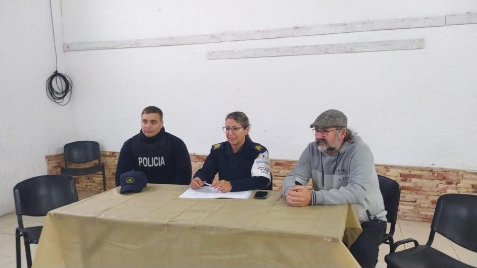 Mesa Seguridad de barrio Santos Garrido de Minas Dos policías de comunitaria y un referente de OSE sentados en mesa de Santos Garrido de Minas