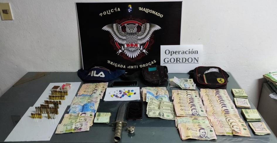 exibición de lo incautado: envoltorios con droga, cartuchos de varios calibres, dinero en efectivo