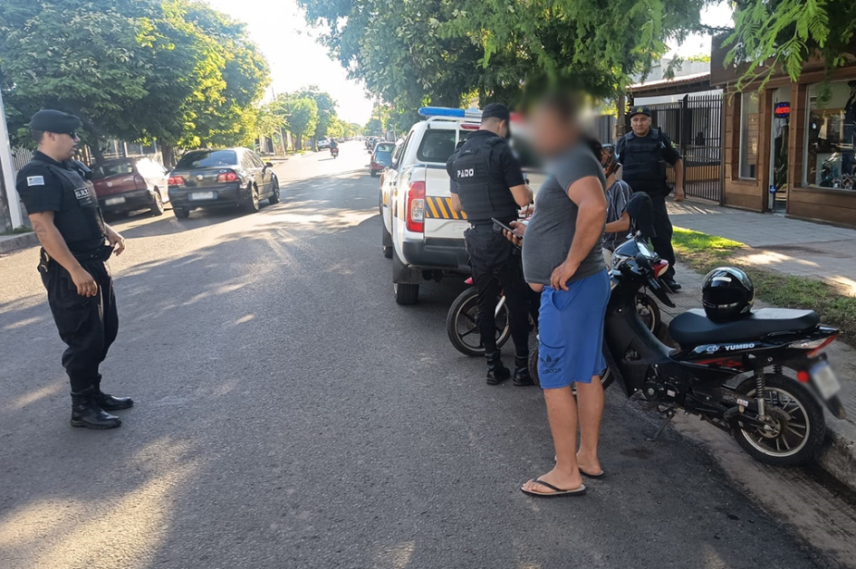 Persona en motocicleta siendo inspeccionado por la policía