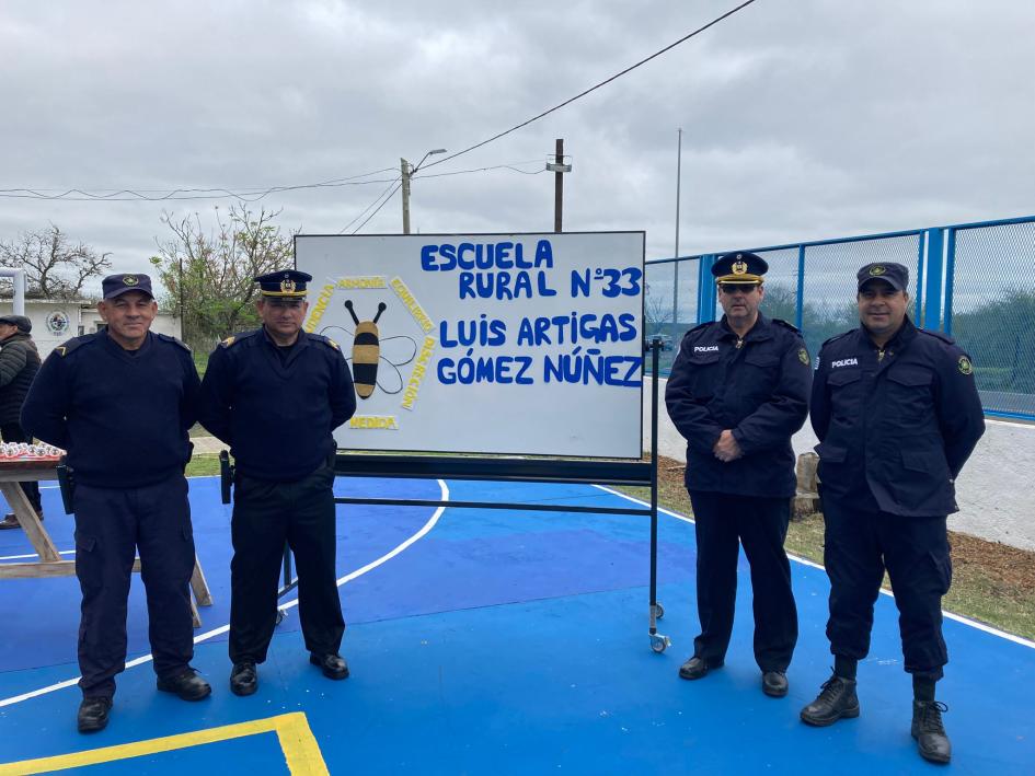 Personal policial posando junto a cartel de la Escuela N° 33. Personal policial posando junto a cartel de la Escuela N° 33.