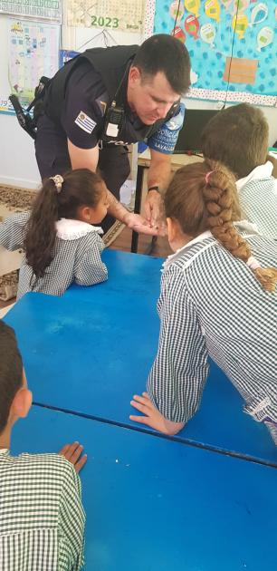 Policía comunitario con alumnos de jardín Policía comunitario con alumnos de jardín