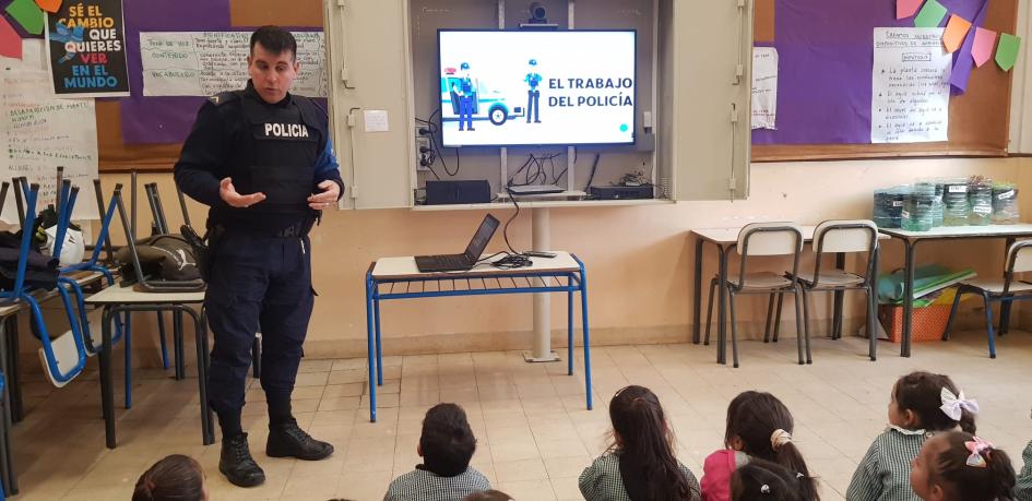 Policía comunitario con alumnos de jardín mostrando presentación Policía comunitario con alumnos de jardín mostrando presentación