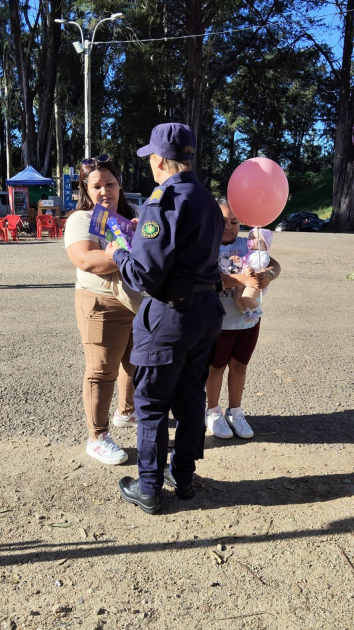 Policía difundiendo información a una madre junto a una niña sobre violencia doméstica y género