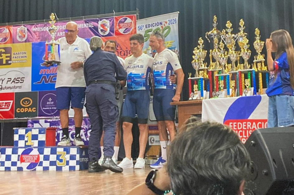 Policía entregando premio en podio a uno de los ganadores de las 500 Millas del Norte.