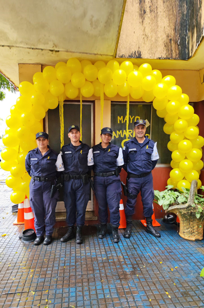 Policías Comunitarios frente a la puerta de acceso a la Oficina Comunitaria decorada