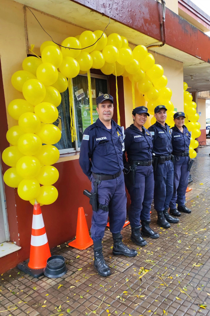 Policías Comunitarios frente a la ventana de la Oficina Comunitaria decorada