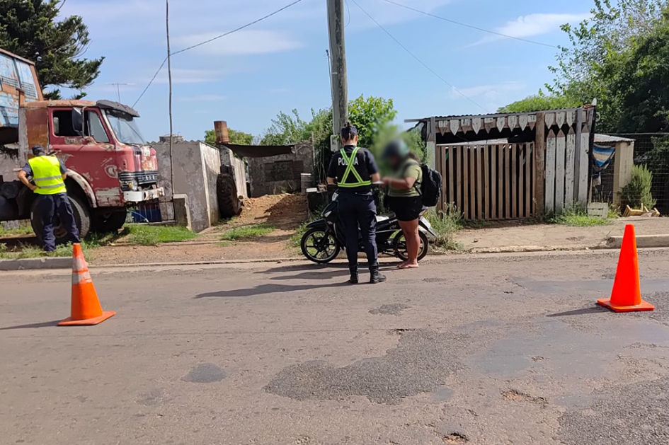 Policías inspeccionando una moto con ocupante.