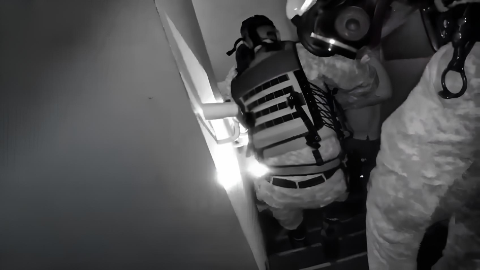 Policías de la Guardia Republicana con mascaras extrayendo personas de edificio durante incendio