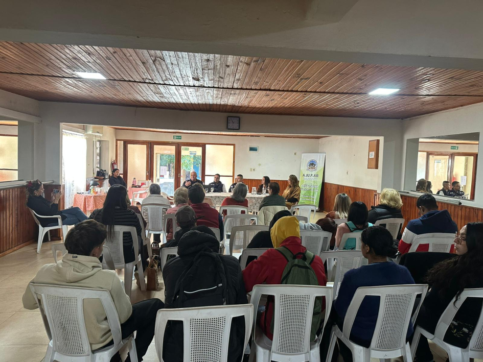 Reunión con asistentes sentados escuchando una charla en mesa principal